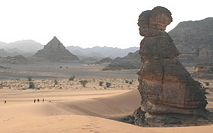 Riesige Felsskulpturen liegen auf sandigen Ebenen und erheben sich aus Dünen, Akakus-Massiv in Südlibyen